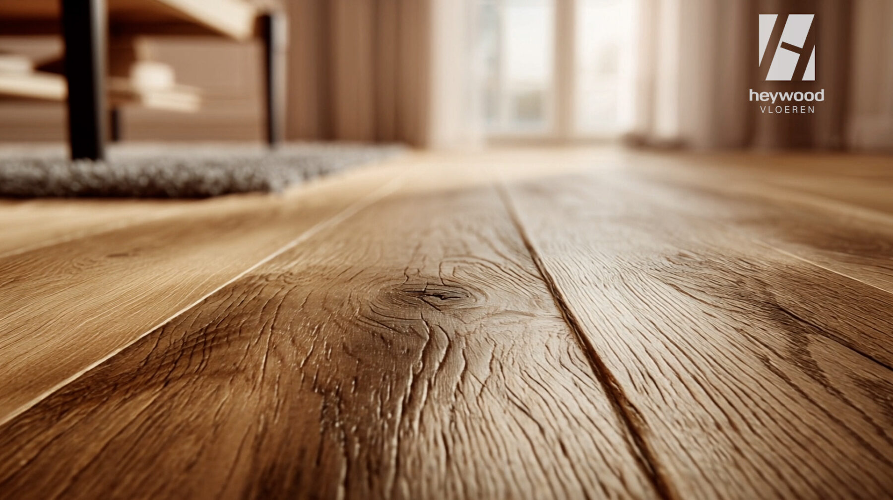 Close-up of natural wood flooring in a softly lit interior with the Heywood logo.